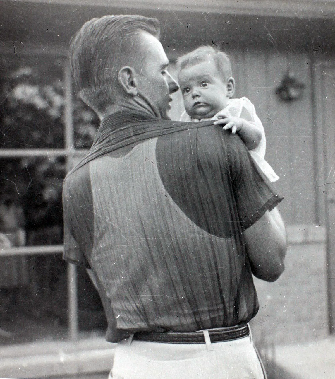 Baby Cathy, held on her father's shoulder
