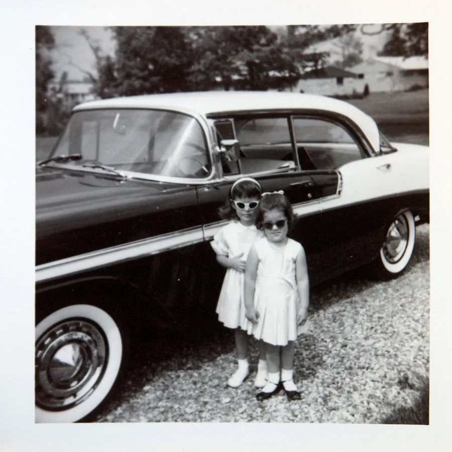Little Cathy and her sister beside the family car